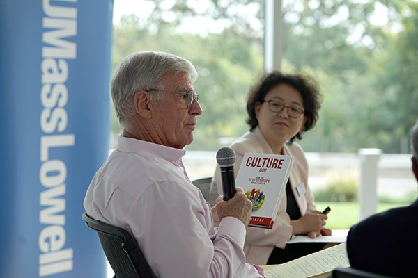 Robert Stringer holds a copy of his book while Yi Yang looks on