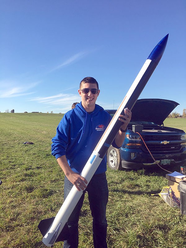 Luis Meyer, vice president of the UML Rocketry Club, holds the Astrohawk rocket 
