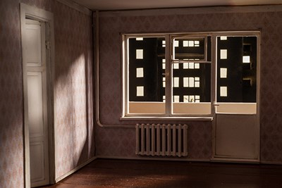 Photo of model of mostly empty room with window looking onto the walls of another building