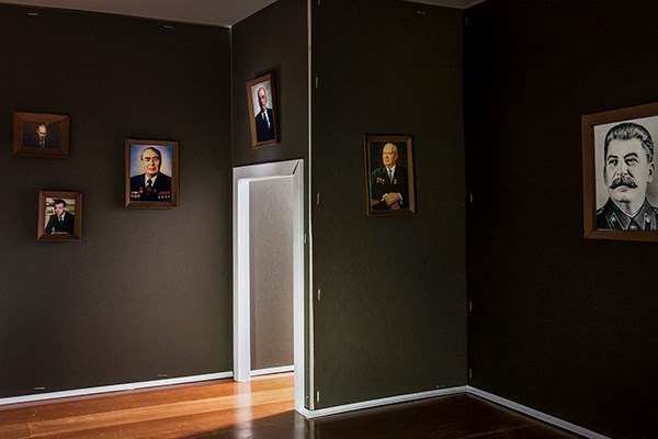 Photo of model of empty rooms with portraits of Soviet and Russian authoritarian leaders including Vladimir Putin and Josef Stalin