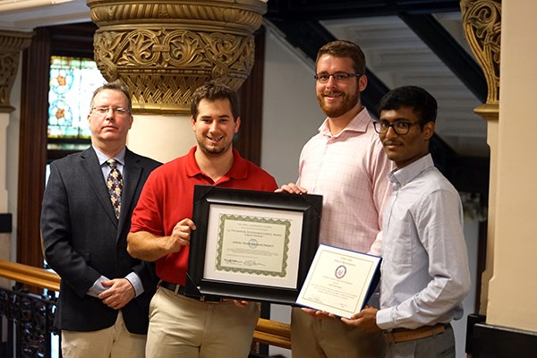 Engineering students and faculty member John Palma pose with their award