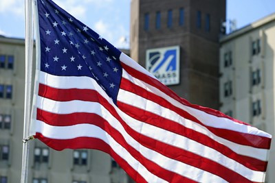 An American flag waves in front of Fox Hall