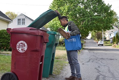 Bora Chhun checks a recycling bin for contamination.