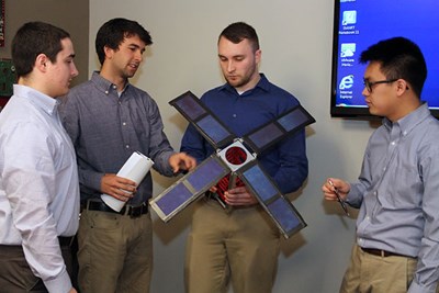 Team members with a satellite model