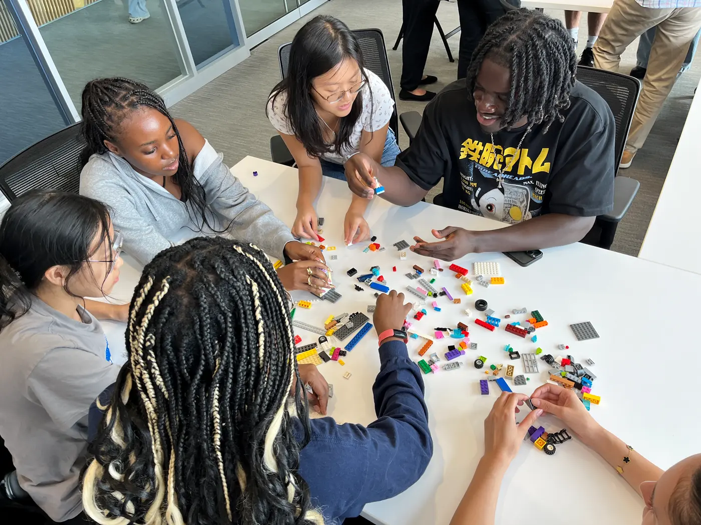 Group of students sitting around a table making LEGOs