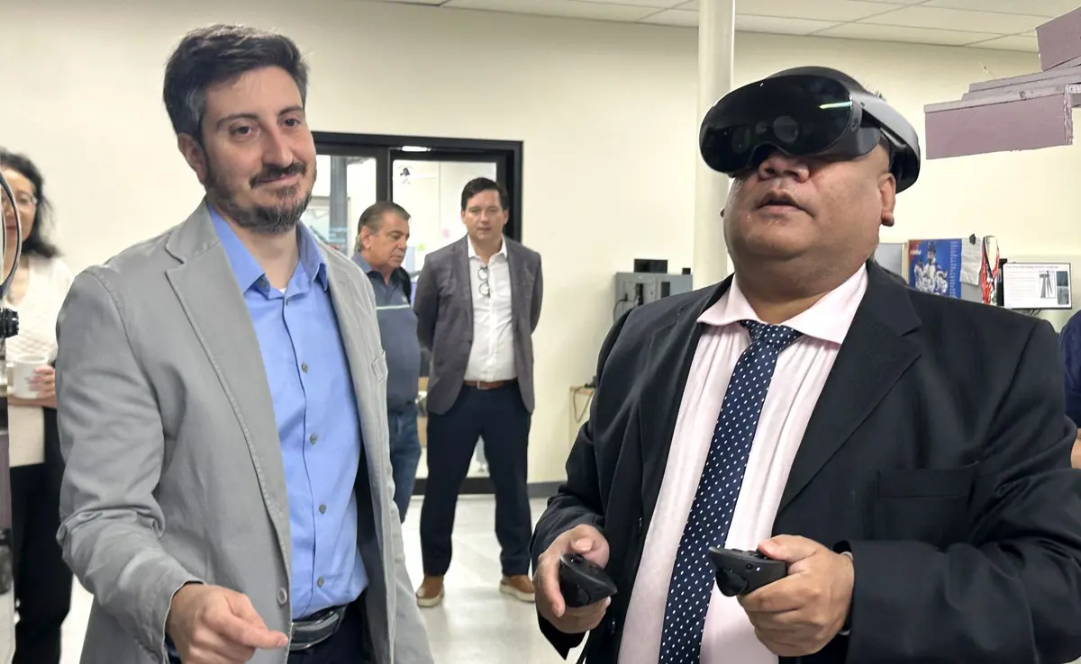 Huzefa Kagdi uses a virtual reality headset as Alessandro Sabato looks on.