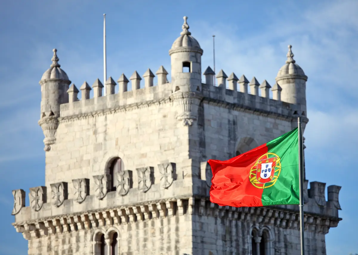 Belem Tower in Lisbon and Portuguese national flag.