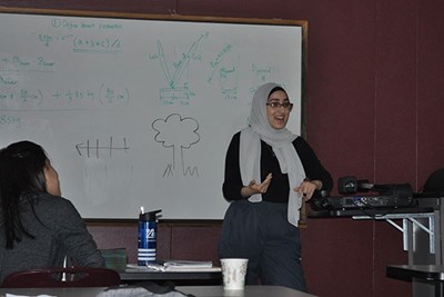 Salwa Alhawi speaks in front of whiteboard