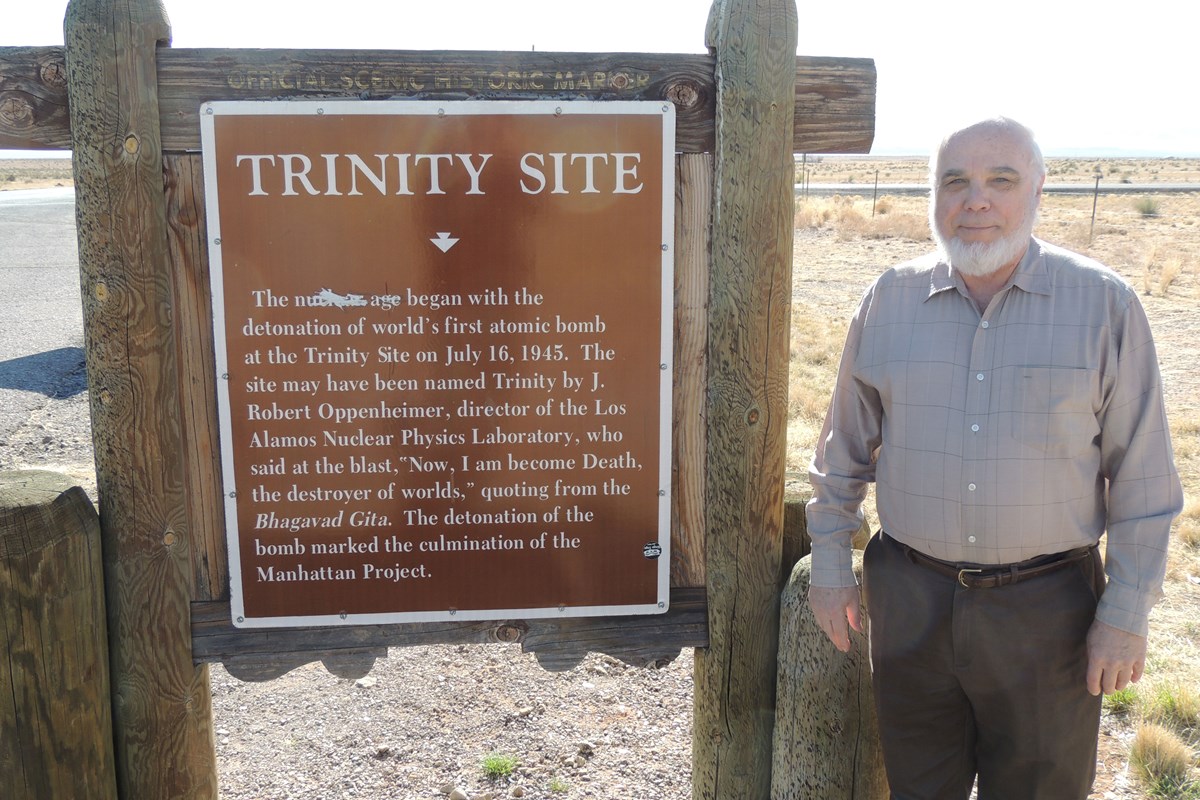 Prof. Nelson Eby standing next to the Trinity site sign.
