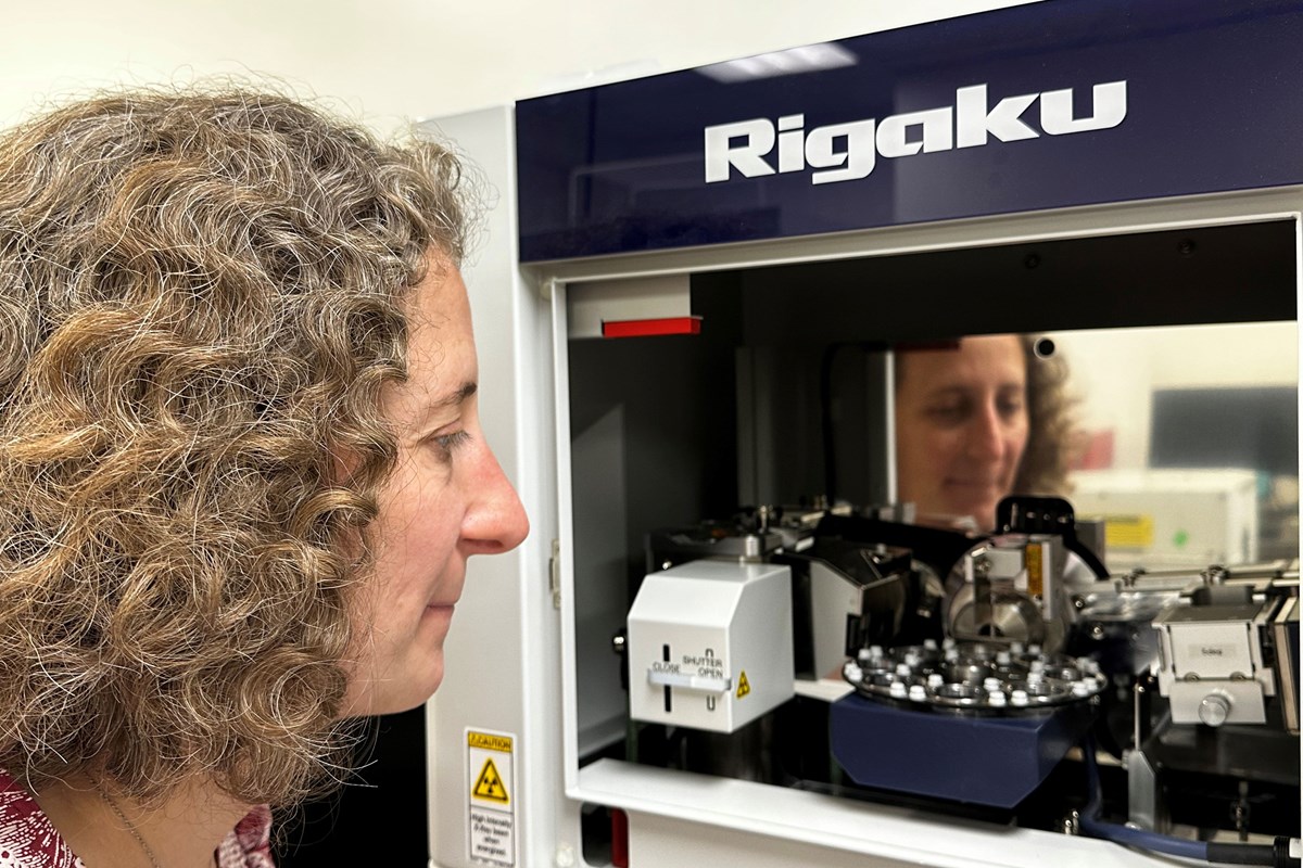 Assoc. Prof. Kate Swanger looking inside an X-ray diffractometer. 