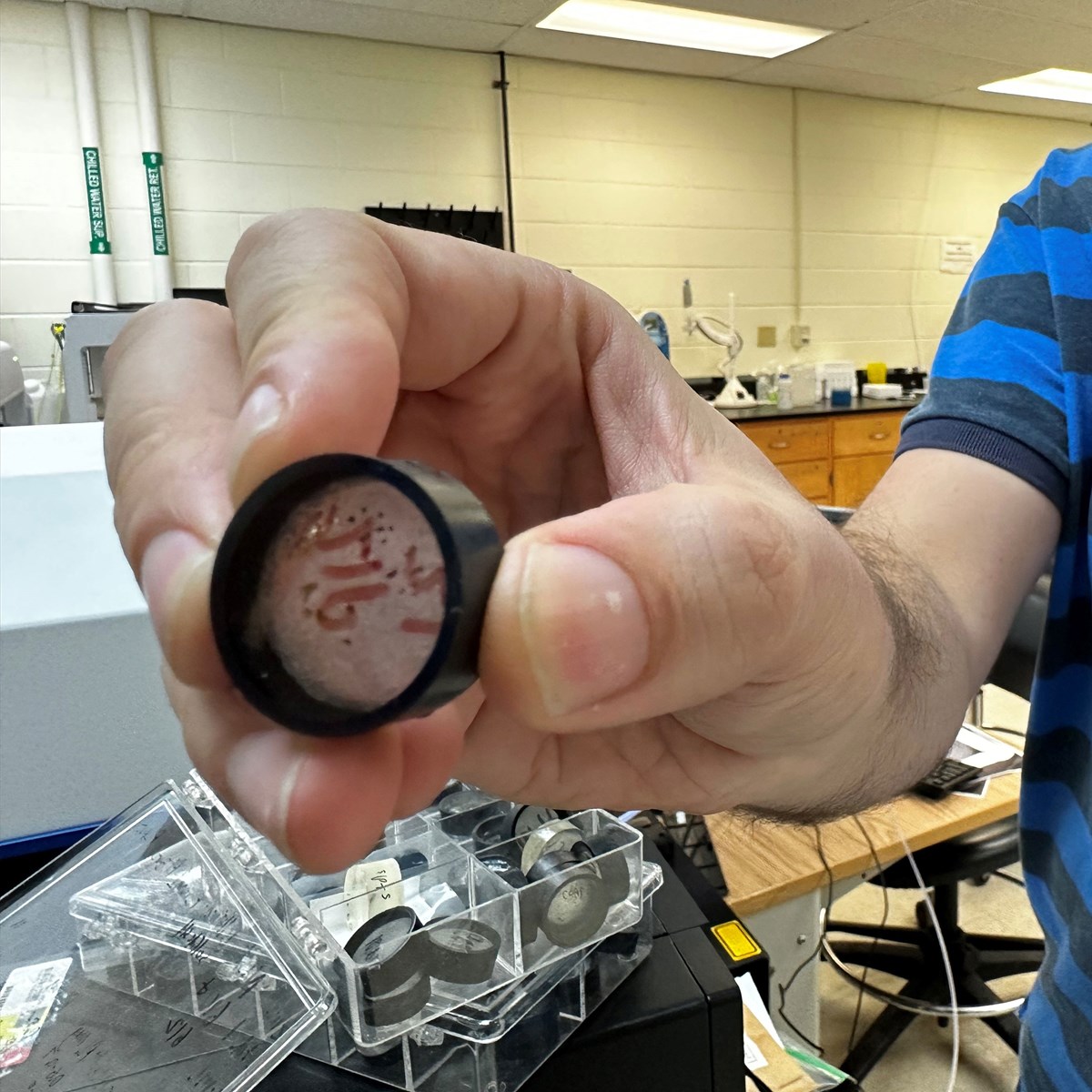 Student holding a grain of sand containing Zircon. 