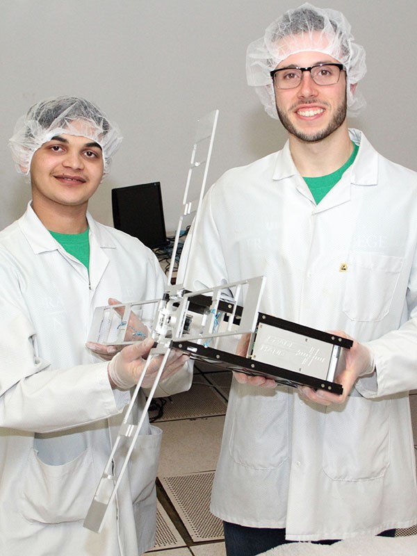 SPACE HAUC program managers and mechanical engineering graduates Sanjeev Mehta ’18, left, and Sean Freeman ‘20 with the satellite