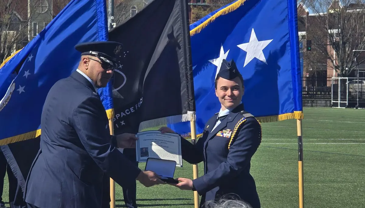 Lieutenant Colonel Jovon Williams and Schuyler McCullought in front of Air Force and Space Force flags.