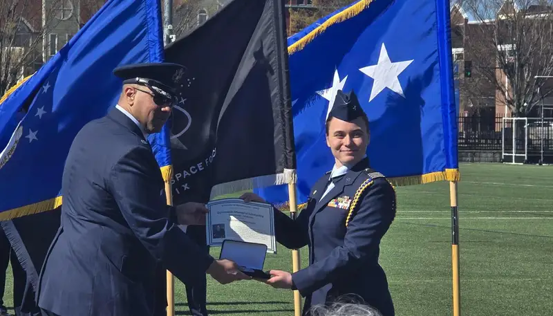 Lieutenant Colonel Jovon Williams and Schuyler McCullought in front of Air Force and Space Force flags.