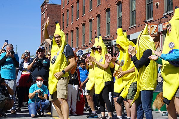 People dressed in banana suits dance in the street