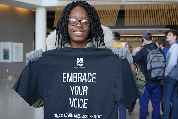 First-year UML student Claudiegh Decoline of Kappa Delta Phi holds up a Take Back the Night t-shirt