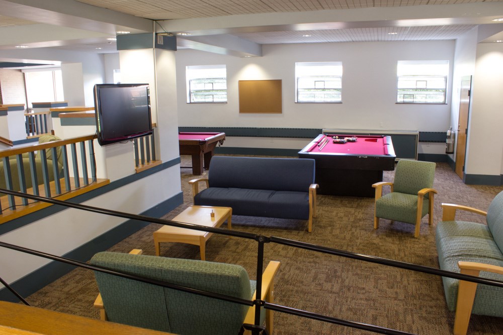 Sheehy Hall lounge area and pool tables. All the rooms are suite-style with a bathroom and a common area. Sheehy Hall is located on South Campus and has the best view of the Merrimack River!