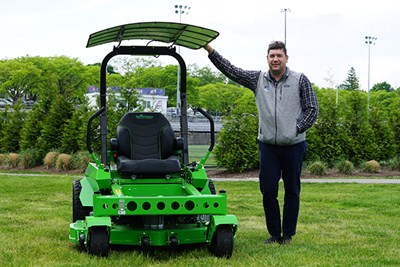 Erik Shaw poses with the new electric mower