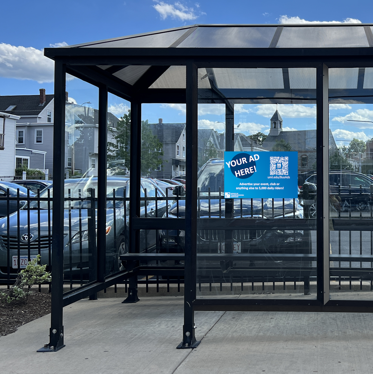 A blue example advertisement is displayed in the window of a bus shelter