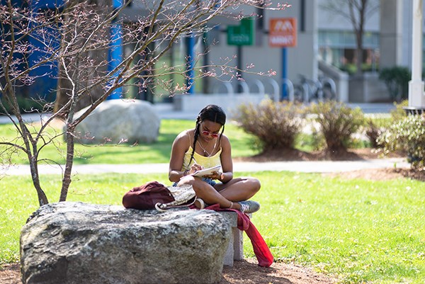 A student studies outside on South Campus