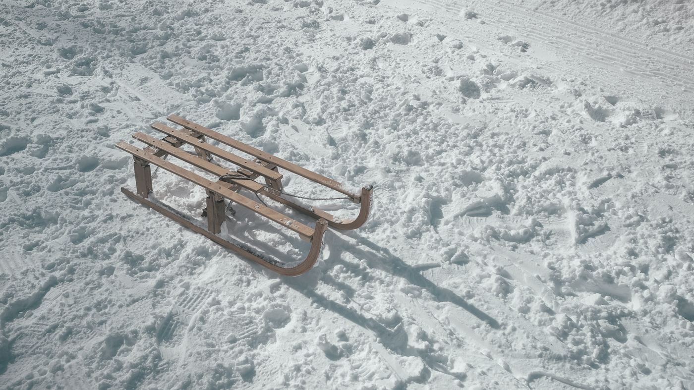Sled on ground with footprints in snow