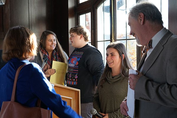 Vice Provost Julie Nash, left, and sociology lecturer Thomas Pineros-Shields, right, chat with students after their presentation on college debt
