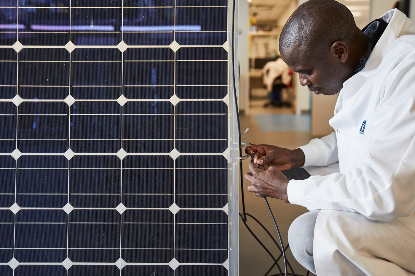 Benard Tabu connects a solar panel to lab equipment in the Perry Energy Lab