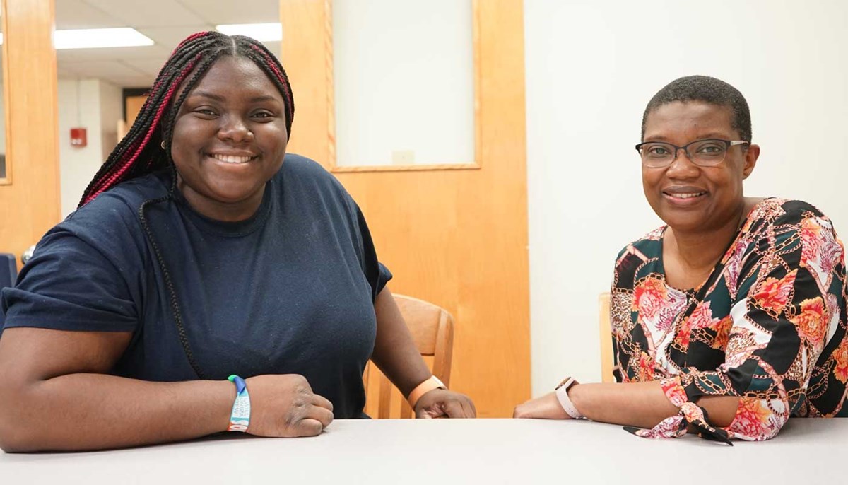 UMass Lowell Chemistry Assoc. Prof. Khalilah Reddie and biology student Sonma Agunda seated at a table