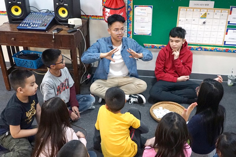 Sitting cross-legged on the floor with a dozen children at the Cambodian Mutual Assistance Association of Greater Lowell (CMAA), Manning School of Business junior Sopheak Mean has the room’s undivided attention as he leads a vocabulary exercise