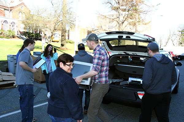 Students unload electronics from a car