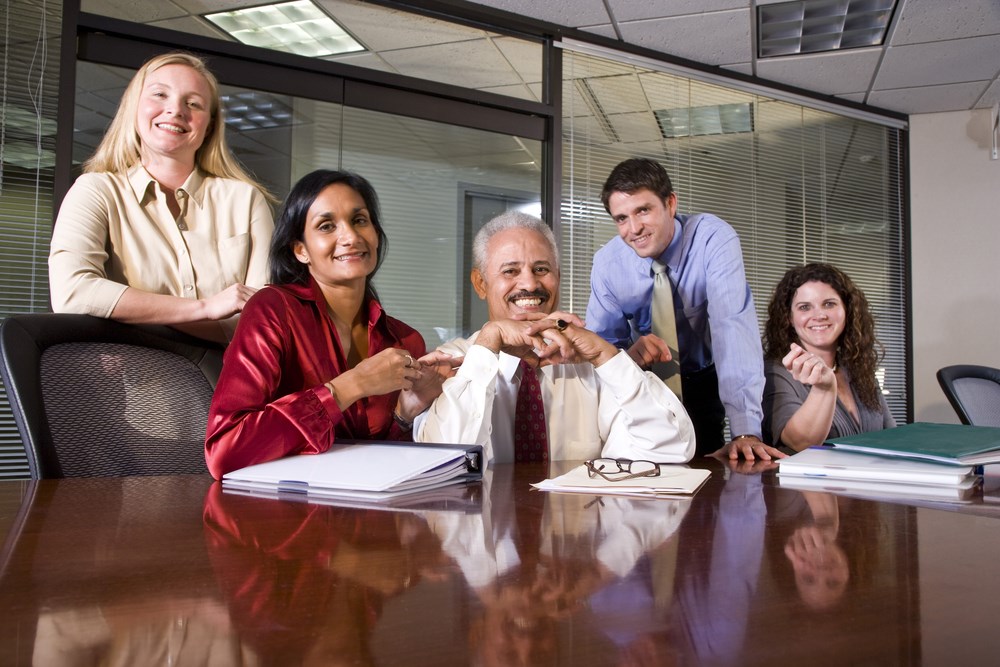 Stock image of people smiling around a table - Steering Committee Photo