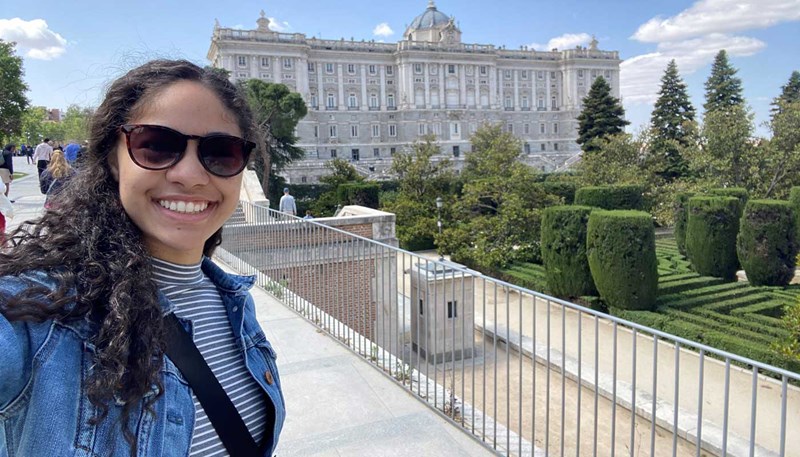 UMass Lowell student Stephanie Ceballos stands outside the Royal Palace in Madrid during a study abroad trip.