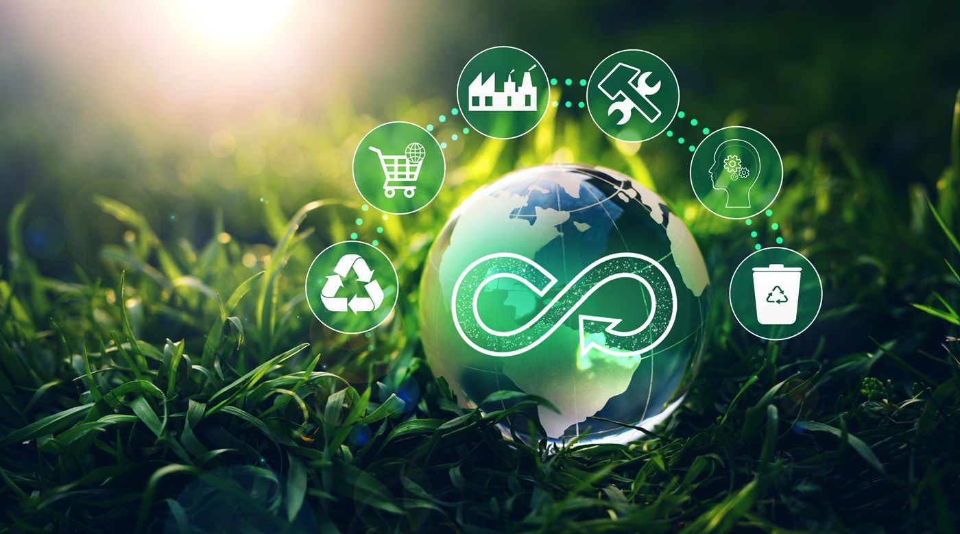 Circular economy graphic: globe in grass with circles above for recycling, shopping cart, factory building, hammer and wrench, gears inside head and trash can.