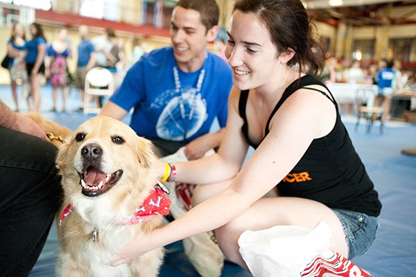 Students pet stress-relief dog at the Campus Rec Center.