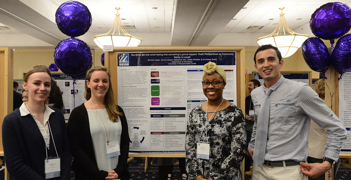 Three female and one male students pose for a group photo at the UMass Lowell Student Research Symposium