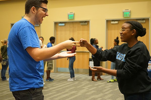 Students in UMass Lowell's new River Hawk Scholars Academy plan rock, paper, scissors at a welcome event.