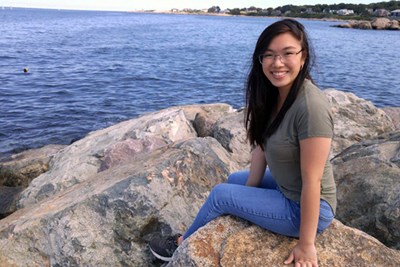 Student Kimberly Ng poses along a shoreline 