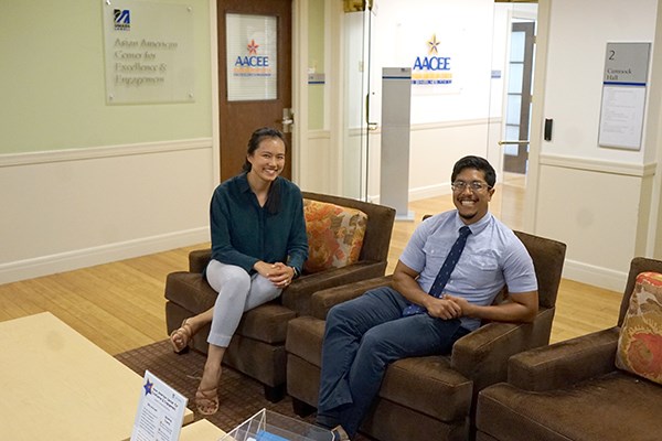 Two people sit in chairs in an office lobby