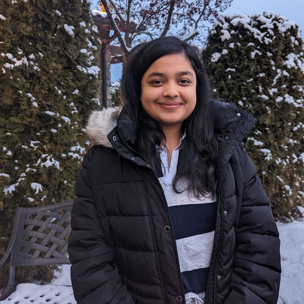 Swarnima Dalal outside in front of a snowy tree smiling at the camera.
