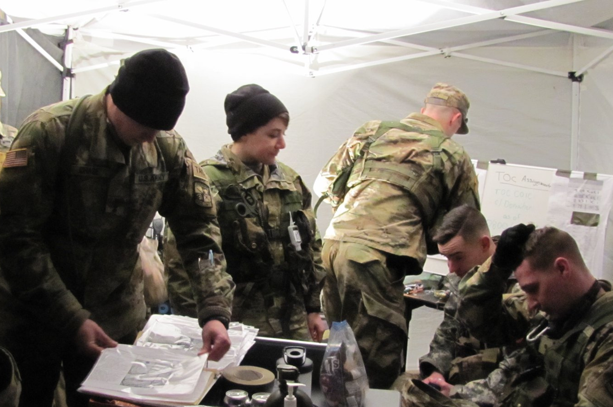 Cadets in a tent looking over documents