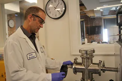 Image shows Jason Marshall working in a lab at the Toxics Use Reduction Institute at UMass Lowell.