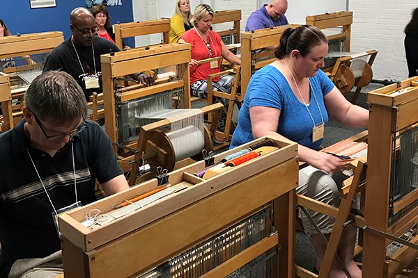 Teachers weave on manual looms at the Tsongas Industrial History Center in Lowell