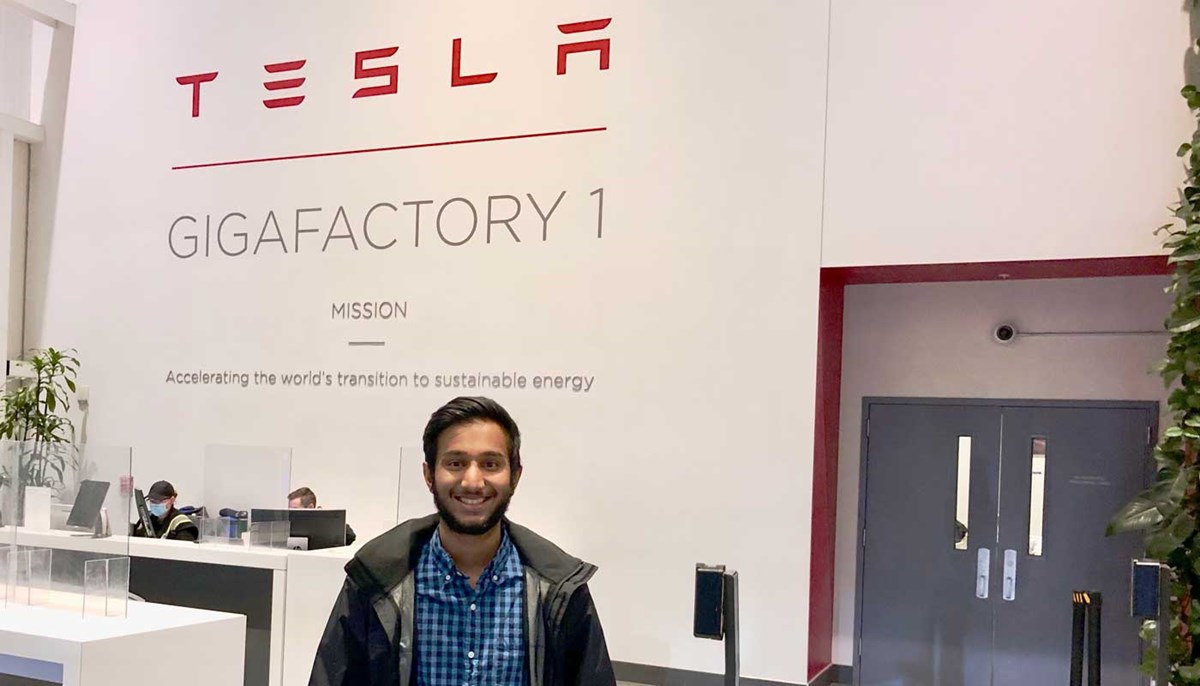UMass Lowell student Teerth Patel stands in the lobby of Tesla, where he completed a manufacturing engineering internship.