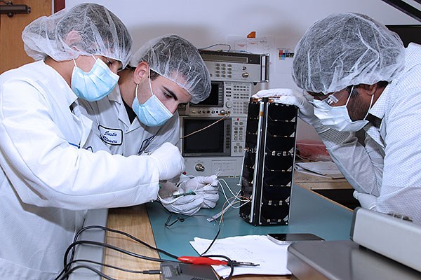 Student researchers testing the satellite