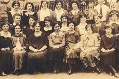 Sepia-tone archival photo of group of teachers from early 20th century