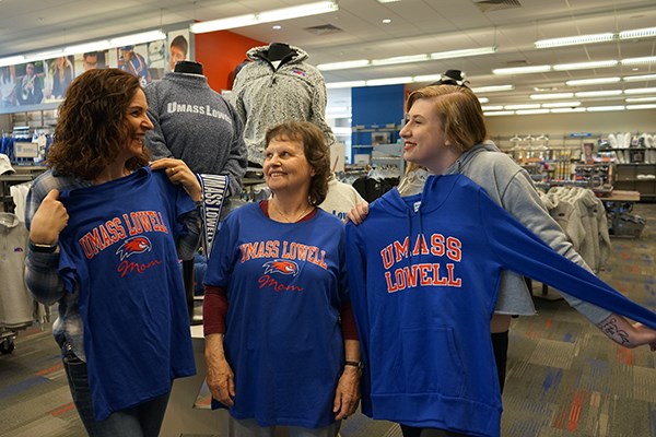 Deirdre Hutchison and Mary Humble check out UMass Lowell Mom shirts while Georgina Hutchison looks at a UMass Lowell shirt