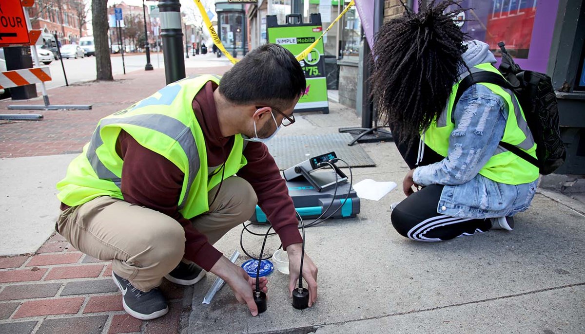 Tiana Robinson works with another student to conduct ultrasonic testing of sidewalk concrete slabs to check their thickness and condition
