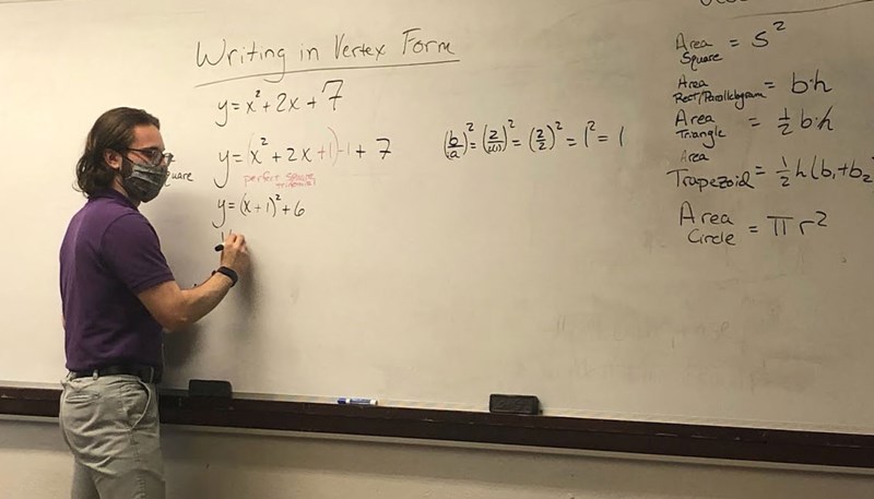 Tom Heywosz writes formulas on a white board
