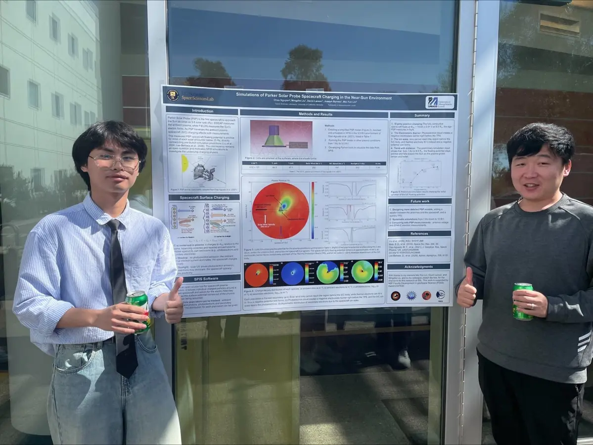 Two men standing next to a scientific poster