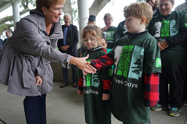 Jacquie Moloney shakes hands with young volunteers